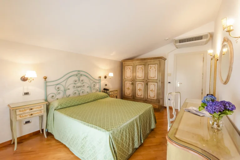 Spaziosa e opulenta stanza King Deluxe al Belvedere Hotel di Forte dei Marmi, con letto king-size, arredi lussuosi e vista mozzafiato